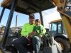 Carlos Godinez of Robert Wallick & Associates, based in Orlando, gets help from Carlos Jr. while trying out a Caterpillar 416D backhoe.