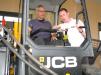 Francisco Tizon (L), international business consultant, Atlanta, Ga., tries out this JCB 225eco skid steer loader with help from Tom Fraser, regional product specialist,  JCB.