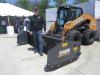 Wayne Smith, Arctic Snow & Ice Control, stands in front of the 10-ft. sectional pusher attached to a Case SV340 skid steer. 