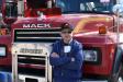 Dutch Reeser, vice president of DRC Inc., Fountainville, Pa., relaxes against a Mack truck waiting for the auction ring to make its way outside