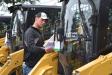 James Koller (L), foreman of First Rate Landscape, Morristown, N.J., checks out the price tag of a Caterpillar skid steer.