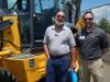 Looking over a John Deere backhoe are Gary Reinfried (L) of J. Campoli & Sons, Cresskill, N.J., and Chad Haring, John Deere territory sales manager.