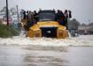  People catch a ride on a Caterpillar 745C articulated truck down a flooded street as they evacuate their homes after the area was inundated with flooding from Hurricane Harvey on Aug. 28 in Houston, Texas. See page 54 for more.
(Joe Raedle/Getty Images)