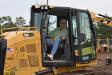 Maurice Corrigan, owner of Maurice L Corrigan and Sons, Southampton, N.Y., checks out the controls of a Caterpillar dozer.