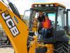 JCB Territory Sales Manager Clay Durham offers some tips to Lindsey Reid, a member of the board of directors of the Company Wrench Family Charitable Fund, as she attempts the skill challenge on this JCB 3CX backhoe loader.

