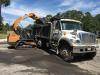 This Case TV380 compact track loader, equipped with the 72-in. Blue Diamond broom bucket, dumps another full load of ground material into a dump truck.