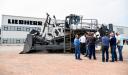 Crowd of customers discuss the PR 776 dozer with product specialists.
