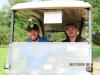 Travis Mills (L) and Mike Liscomb — a new amputee working at the Travis Mills Foundation — cruise the course in a cart.