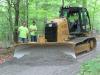 Volunteers Dave VanDerGroef, Rich and David Gaynor, grade a site with a Cat DK2LGP dozer donated by Foley Cat.