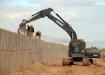 Seabees assigned to Naval Mobile Construction Battalion (NMCB) 7 place dirt into Hescoe protective barriers utilizing an up-armored excavator at a forward operating base in Helmand Province, Afghanistan.
(Mass Communication Specialist 2nd Class Michael B. Lavender/U.S. Navy photo)