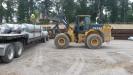 A John Deere 644K wheel loader assists with an Energy Services well pad.