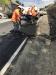 Crews engaged in putting the finishing touches on a newly-paved section of road.
