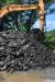 Stockpiles of asphalt are fed to the EvoQuip closed-circuit tracked impactor.

