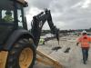 A John Deere 710 backhoe with a hydraulic breaker is demolishing a section of a concrete bridge deck as part of the $25.7 million project in Chula Vista, Calif.