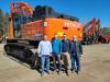 (L-R): Jeff Morse, general manager, Brad Chappell vice president, Corey Chappell, president, and Flip Henry, sales manager, pose with a 2022 Hitachi ZX490.
