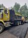 Jon Davis of the town of Parishville highway department operates the truck while a St. Lawrence County paver lays down asphalt.