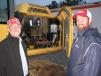 Terry (L) and Brooks Parker, both of Parker Electric, Brooks, Ga., look over a mid-sized Deere excavator in the auction line-up  