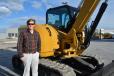 Zach Summers, pictured with a Cat 308 excavator, was on hand for the auction. Summers is the Caterpillar BCP industry rep for the northwest.
 