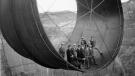 Officials ride in one of the penstock pipes of the soon-to-be-completed Hoover Dam in 1935. (Bureau of Reclamation) 
 