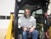 Kevin Kruizenga of Triple K Farms sits at the controls of this Cat 242D skid steer.  
 