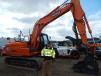 Credem Johnson, co-owner of Double J Masonry, Willmar, Minn., takes a look at this Doosan DX140LC excavator. 