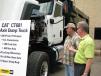 Roy Holmes (L) of Roy R. Holmes Construction Co. Inc., Nesbit, Miss., and Jim Kerschbaum of Thompson Truck Centers talk about a Cat CT681 tri-axle dump truck on display. 
