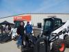 (L-R): Tom Cox, service manager and owner, talks with David Cox, salesman of the year, in front of a Bobcat T870 with a brush cutter and a Bobcat A770 with a stump grinder.
 