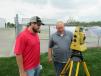 Justin Buenger (L) of Connie Construction talks to Paul Naylor, GeoShack, about Topcon’s PS Series Robotic Total Station.
 