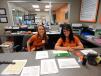 Rachel Olson (L) and Genea Rissell, administrative assistants of Ritchie Bros., greet customers  