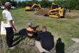 Jason Ross (R), Altorfer condition monitoring specialist, helps attendees demo the new RemoteTask remote control system for Cat D Series skid steer, multi-terrain and compact track loaders.
 