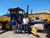(L-R): Chris Mullen, sales; Scott Weness, sales manager; and Ryan Miller, sales, all of RDO’s Burnsville, Minn. location, stand with a new John Deere 672 GP 255 hp motorgrader. 
