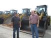 Dave White (L) and Mark Freudinger, both of Quantum Technical, look over the Cat wheel loaders at the sale.
 