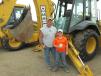 Robert Jones (L) and his son, Owen, of Jones Excavation and Dozing in Tipton, Kan., pose with their latest purchase from the auction — a John Deere 310 SG loader/backhoe.  