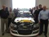 Frank Bart, Wauconda, Ill., mayor (front right) and Garrett Patten, president of Patten CAT (second on the right) stand with the employees of Patten CAT around the Cat race car driven by Ryan Newman.
