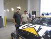 Jose Ceja (L) and Brad Dietrich, both of Schmechtig Landscaping Co. check out the Cat race car on display at the grand opening event. 

