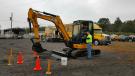 SEI’s Wilkes-Barre, Pa., branch manager Dave Donati (R) goes over the JCB operator skills challenge with Alex Ramer of Penn Township before he starts. The JCB event truck seen in the background was on hand for the event.