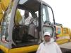 Willie Ross (L) inspects the controls of this Kobelco excavator while Muhammad Yaseen looks over the outside of the machine. 