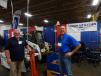 Dan Reetz (L), territory manager of Shaver, holds a post pole attachment at the Truck Utilities booth while talking to Charlie Miller, sales engineer, Truck Utilities, St. Paul, Minn.  
