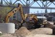 A pair of Cat excavators dig together in a two block area of the city where 29 residential and commercial properties were relocated to make room for the street geometrics of the new bridge.
 