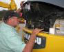Herbert Hare, Hare Tractor, Cullman, Ala., checks the engine of a Komatsu PC78mr mini-excavator.
