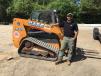 Kody Duke, owner/partner of Precision Landscaping, stands in front of the company’s Case TR310 compact track loader.