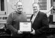 Andru Small (L), Terry Equipment Inc., accepts the Top Ten Distributor award from Kent Godbersen, GOMACO vice president of worldwide sales and marketing. 