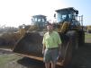 Steve Debaun, president, Track II Corporation, Lakeville, Minn., looks over these two Caterpillar 950K wheel loaders. 