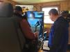 Jason Bissol (R), product support representative, shows a customer how to man the Volvo excavator simulator