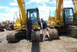 Jude (L) and Joey from Gulfport, Miss., stand with a 2008 Komatsu PC130-8 hydraulic excavator. 