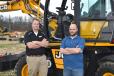 David Pendleton (L), regional business manager of JCB, and Paul Oliver, equipment advisor of Asplundh, stand in front of the new JCB Hydradig, which debuted at ConExpo this past March. 