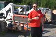 Zach Shumar, sales representative of Shumar Industries, Uniontown, Pa., takes a break from looking at some skid steers. 