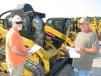 Bruce Lowery (L) of Lowery Properties, Arley, Ala., and Ricky Frazier of R&S Roofing, Ardmore, Ala., look over some of the compact track loaders for sale. 
 