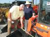 Steve Albritton (L) and Bill Johns, both of Johns & Kirksey Inc., Tuscaloosa, Ala., inspect and measure the buckets on a pair of new Kubota skid steer loaders. 
 
