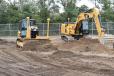 In the demo area, a Caterpillar dozer simulates setting the base layer of a road project, while a Cat excavator digs a detention basin using Trimble technology. 